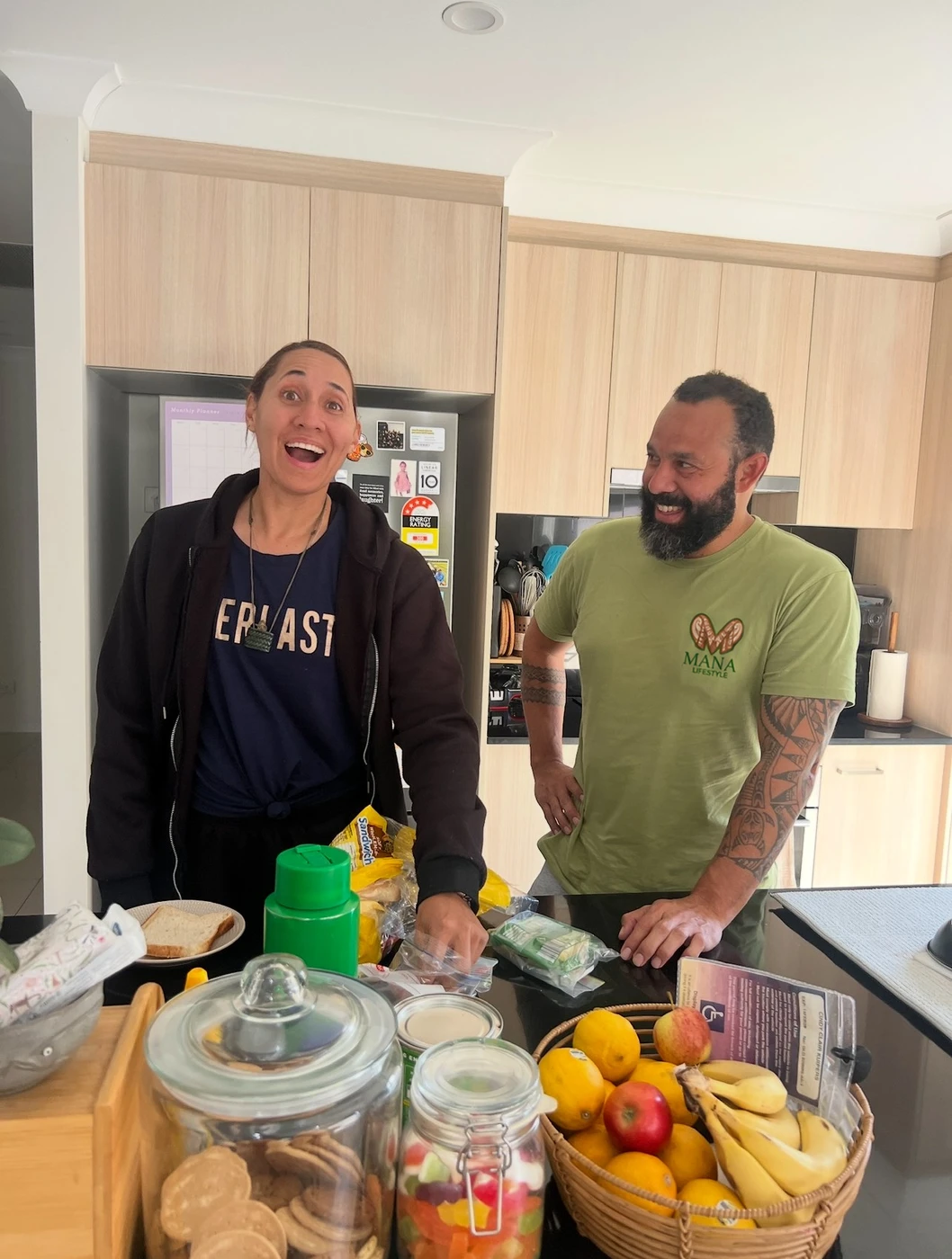 Two people sharing a light-hearted moment in a kitchen